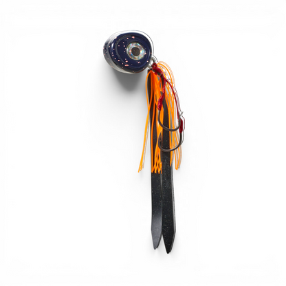 Ocean Angler Slider fishing lure with a dark speckled head, orange silicone skirt, and sharp assist hooks.